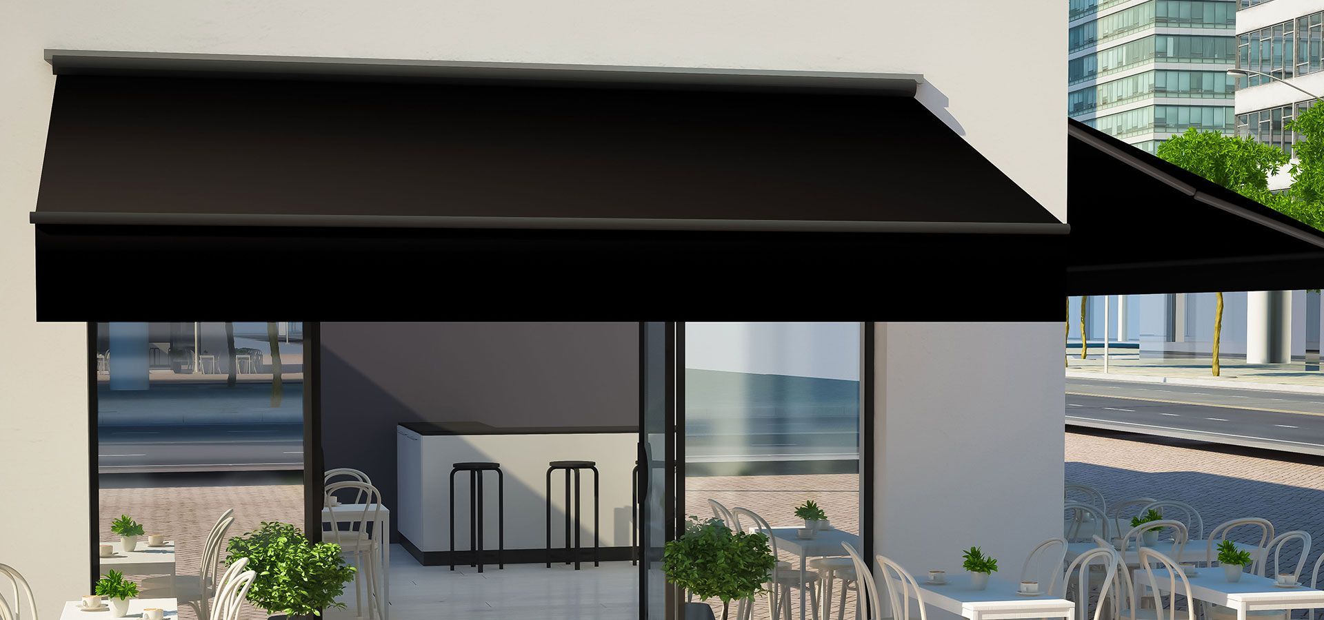 Modern storefront with black awning, glass doors, and outdoor tables on a city street