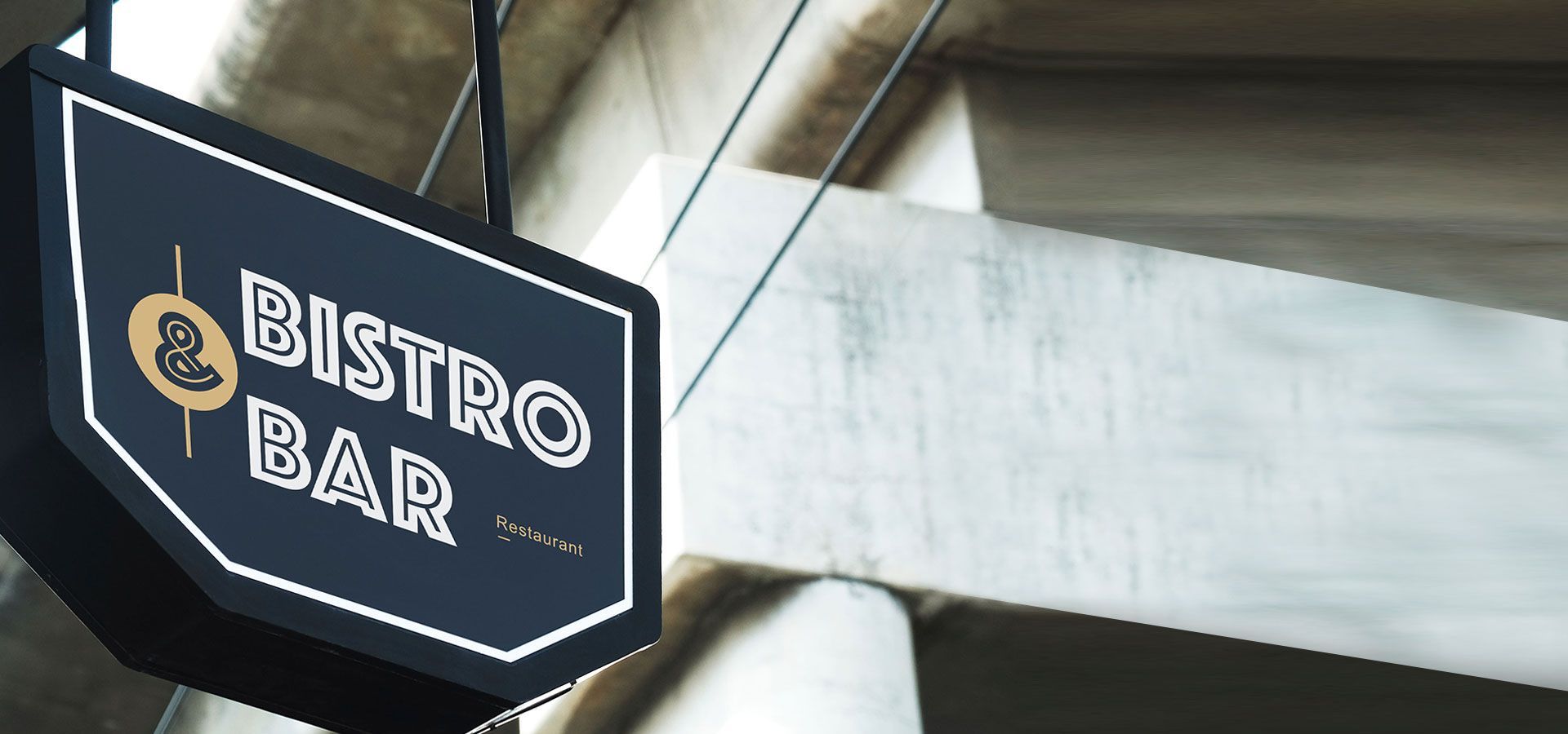 Black hanging sign reading “BISTRO BAR” on a concrete building exterior.