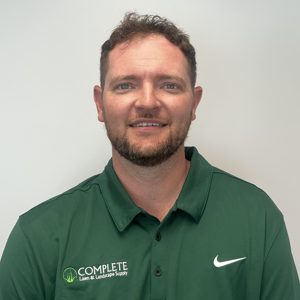 A man with a beard is wearing a green nike polo shirt.