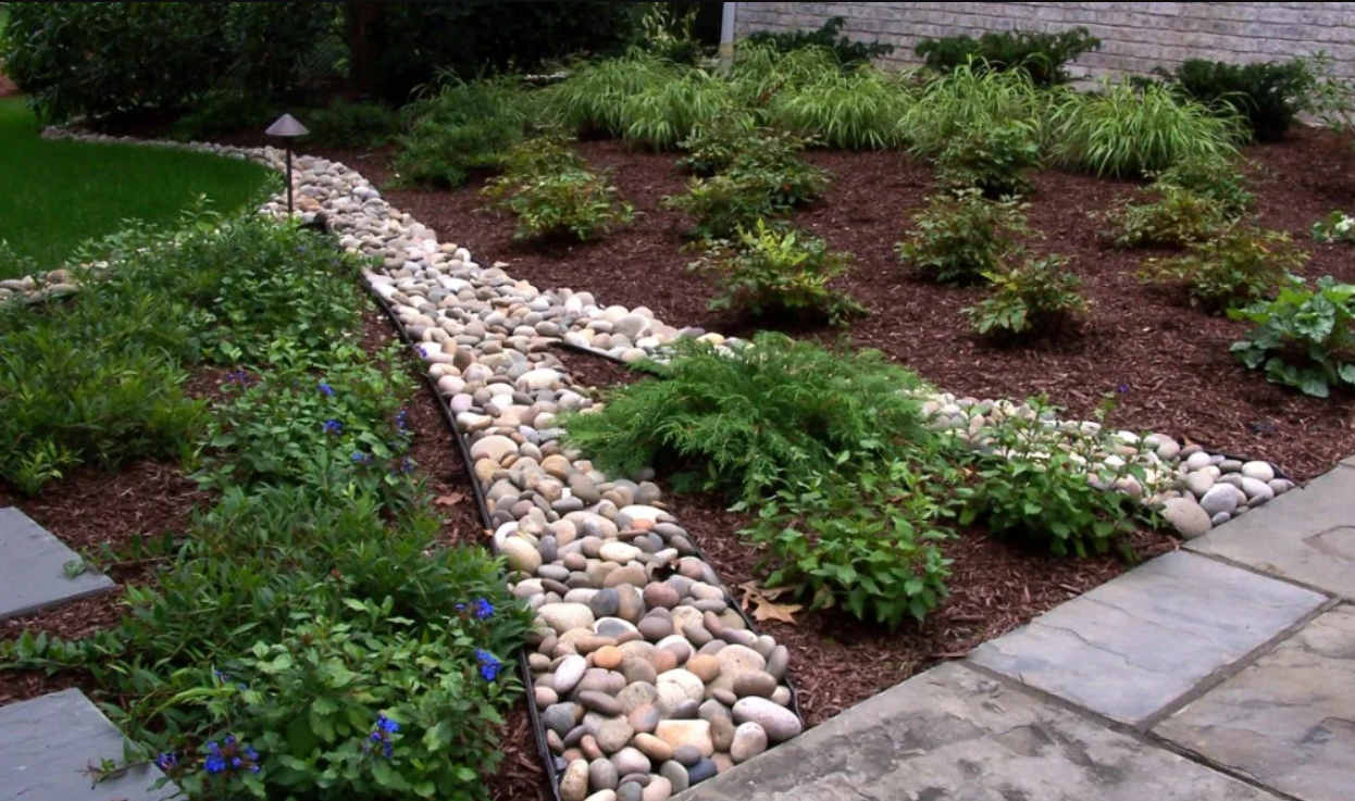 A lawn with a metal edging and red gravel