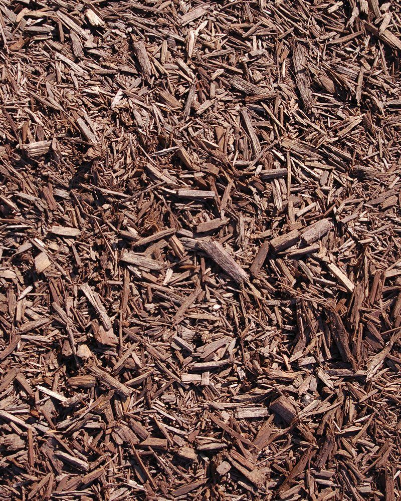 A pile of brown mulch is sitting on the ground.