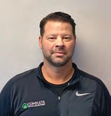 A man with a beard is wearing a nike jacket and a black shirt.