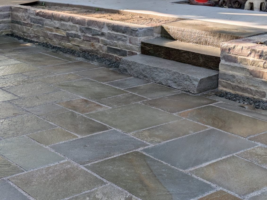A stone walkway with stairs and a stone wall.