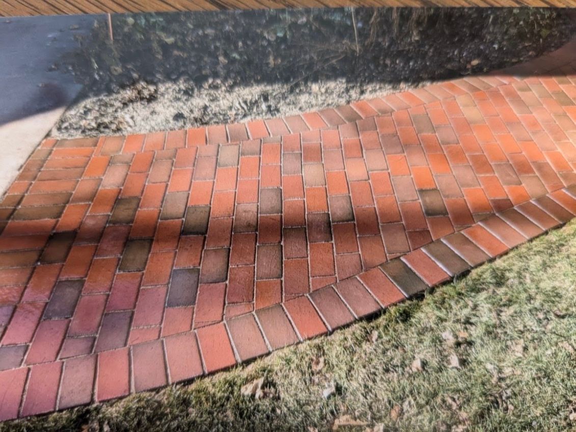 A brick walkway going through a grassy area