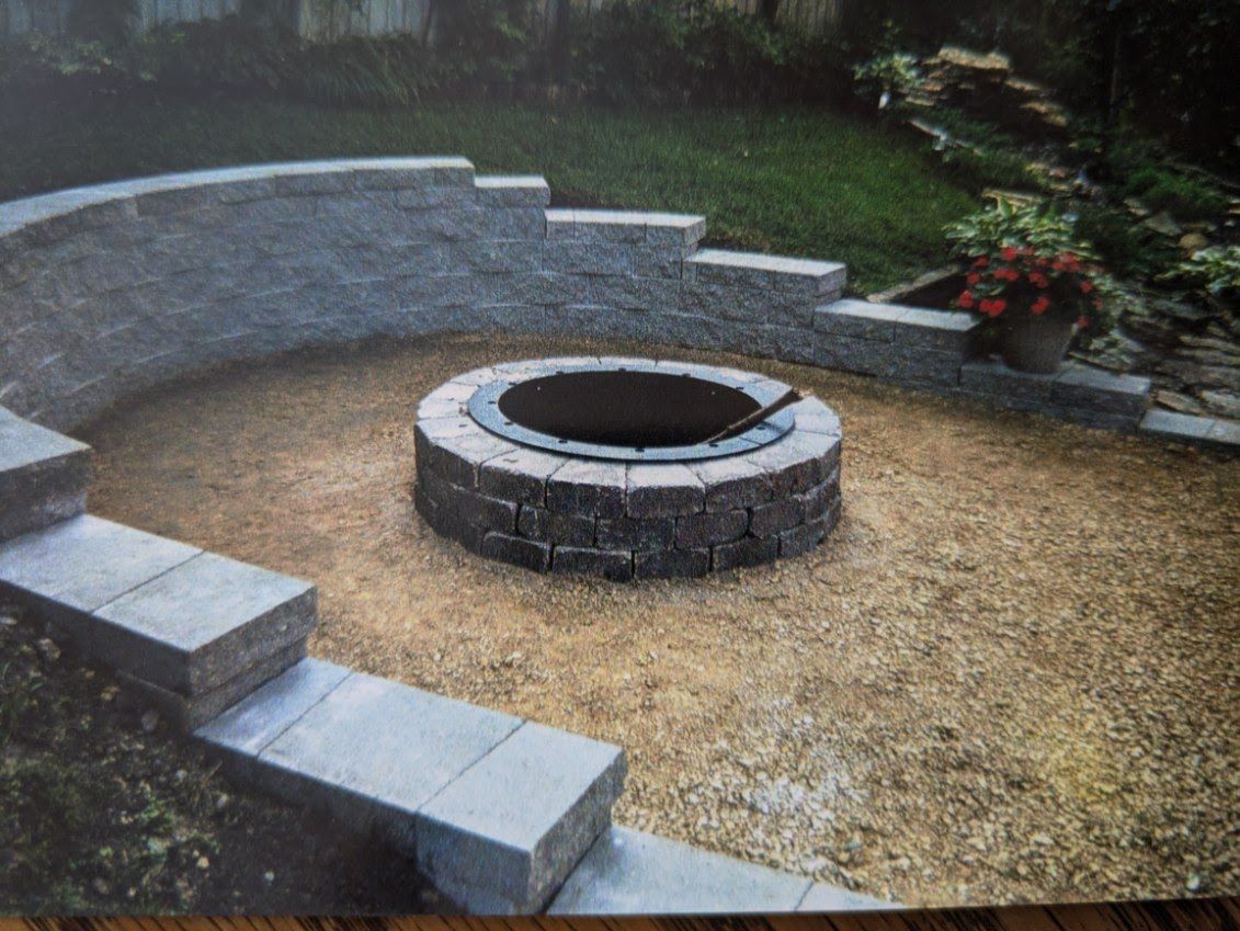 A fire pit is surrounded by a stone wall and steps.