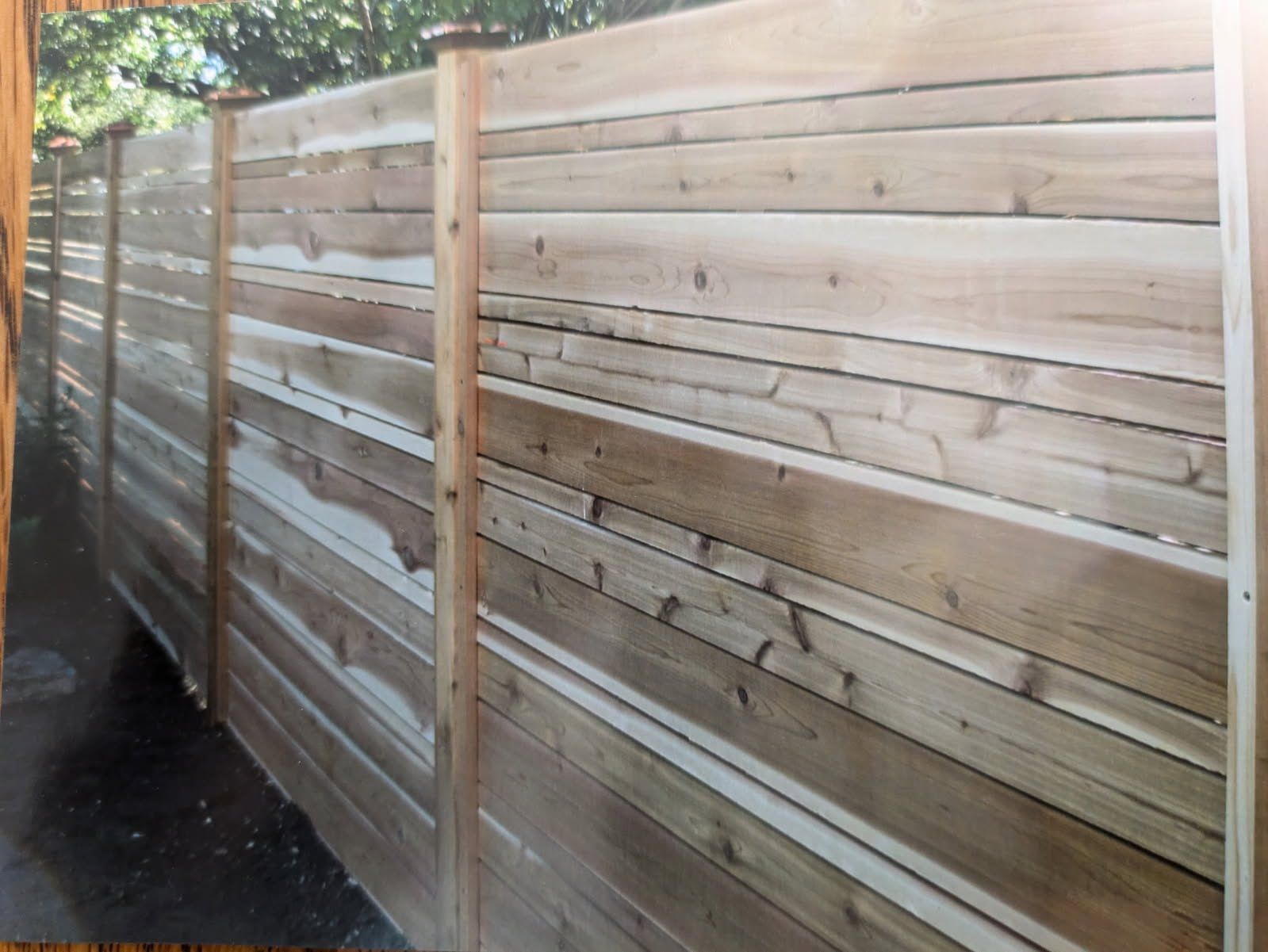 A picture of a wooden fence with trees in the background