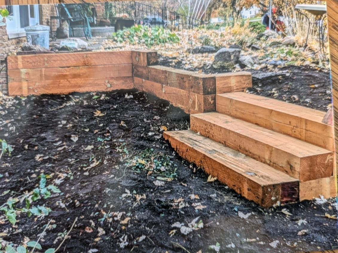 A wooden staircase is being built in a backyard.