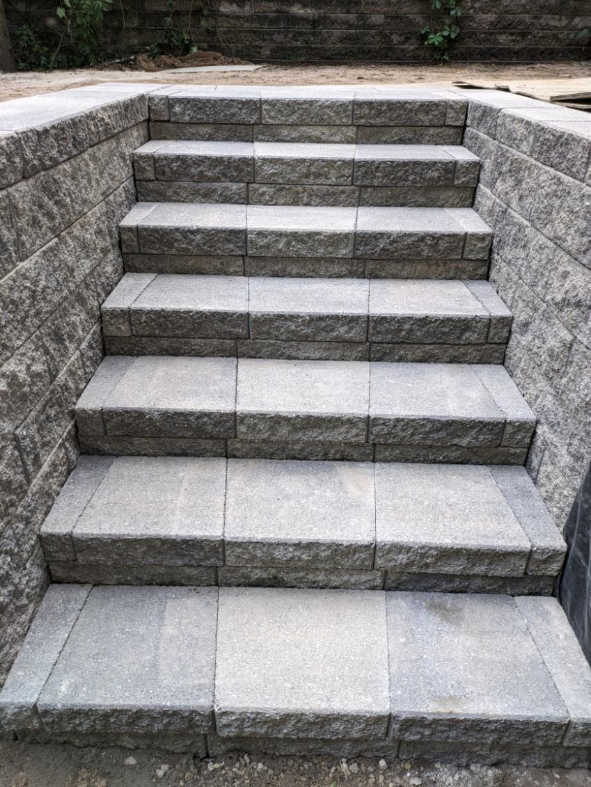 A set of stairs leading up to a brick wall.