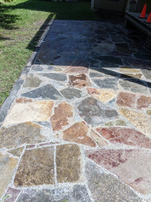 A stone walkway with a lot of different colored rocks on it.