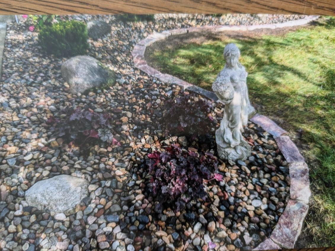 A picture of a garden with a statue in the middle of it.