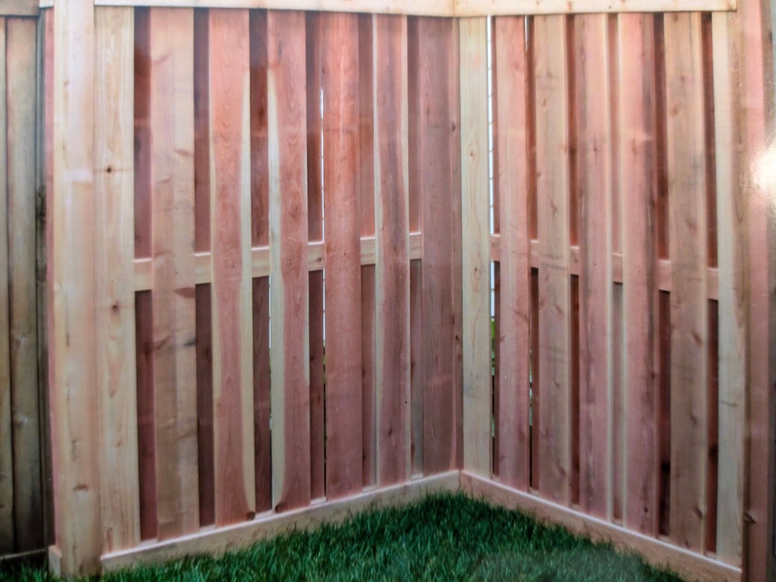 A wooden fence is sitting on top of a lush green lawn.