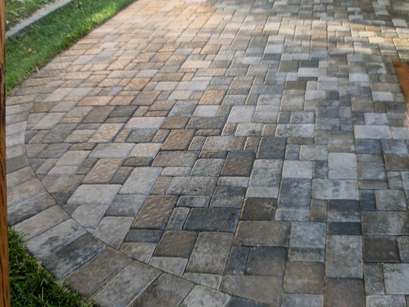 A brick walkway with a wooden fence in the background.