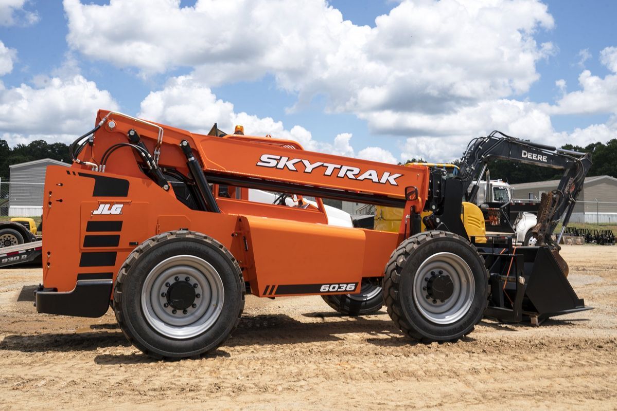 Orange SkyTrak telehandler on a construction site.