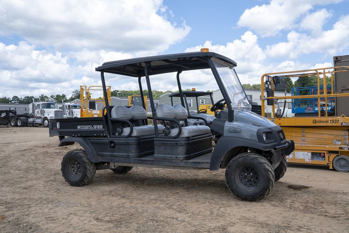 Dark gray utility vehicle with a canopy, parked on dirt.