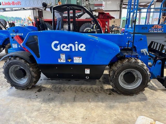Blue Genie telehandler on a concrete floor with black tires.
