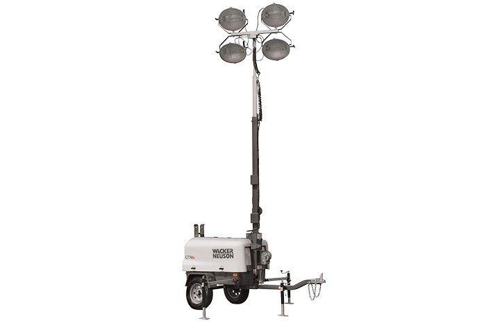 Mobile light tower with four spotlights on a raised mast, mounted on a trailer.