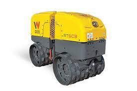 Yellow and gray Wacker Neuson RTsc3 trench roller compacting soil at a construction site.