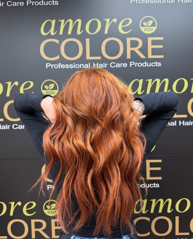Woman with long wavy auburn hair in front of 