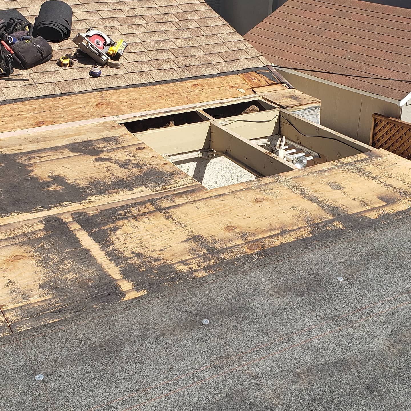 A roof with a hole in it is being repaired.