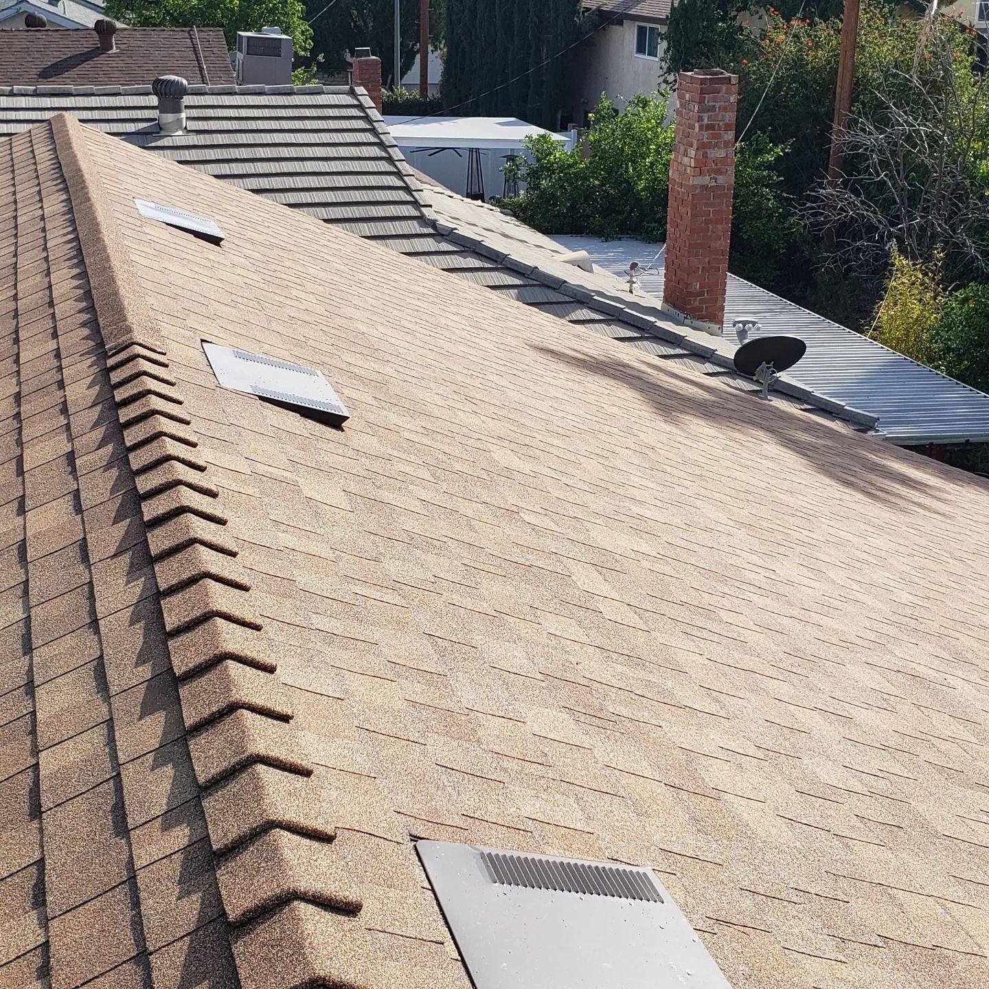 A chimney is being removed from the roof of a building