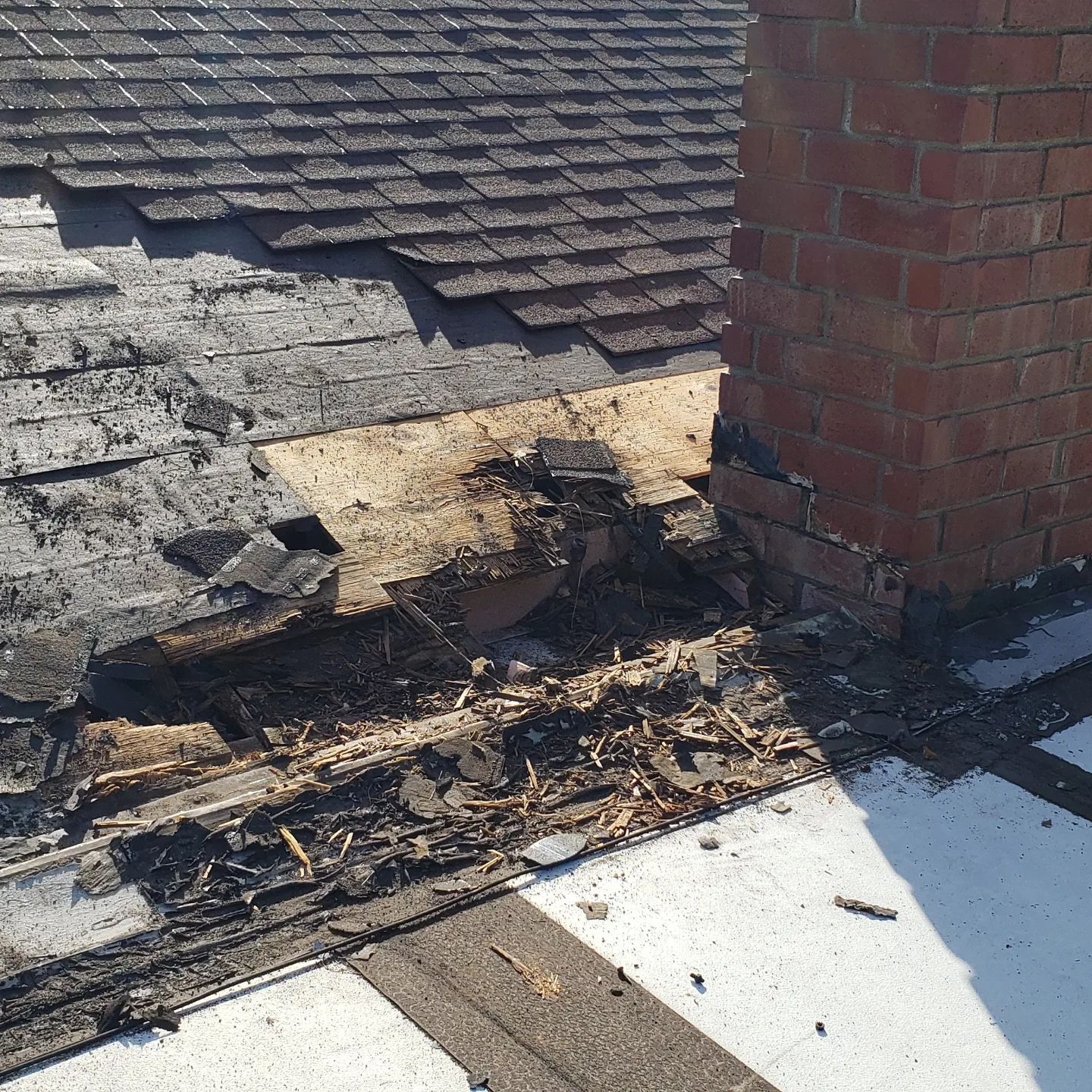 A truck with a crane on the back is parked in front of a house