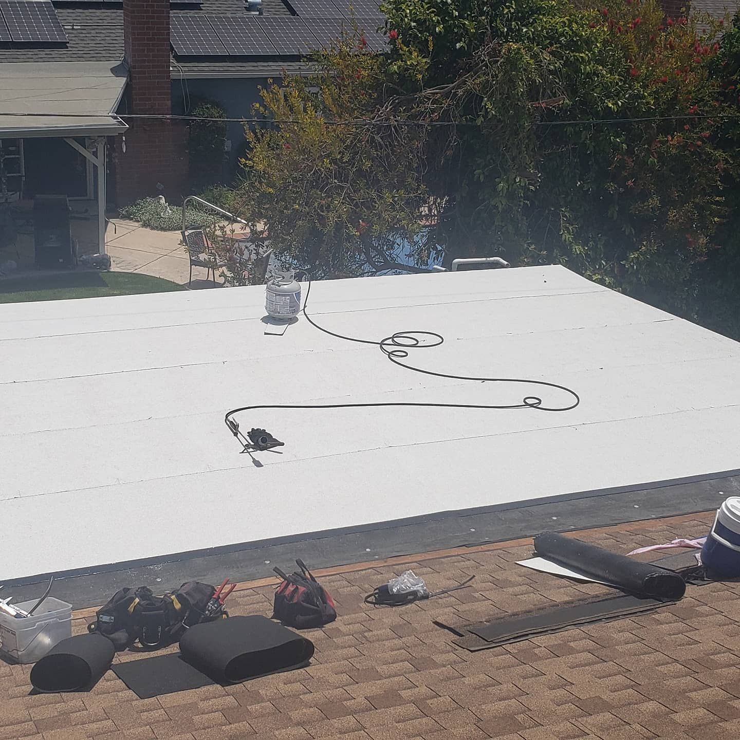 A white roof is being installed on a brick roof.