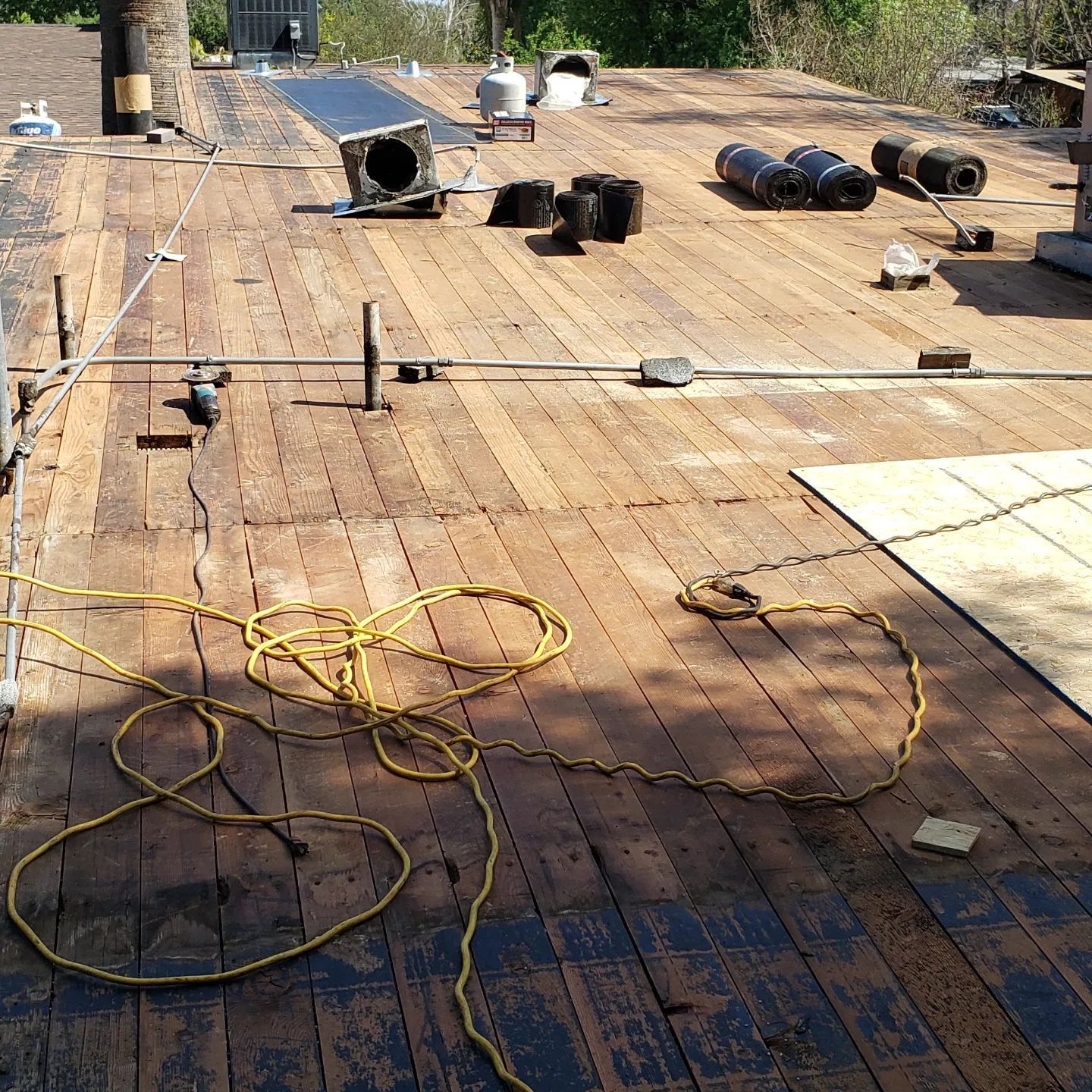 A man is working on a roof with buckets of paint