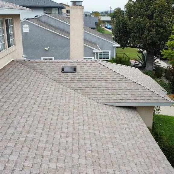 A man in a yellow shirt is working on a roof