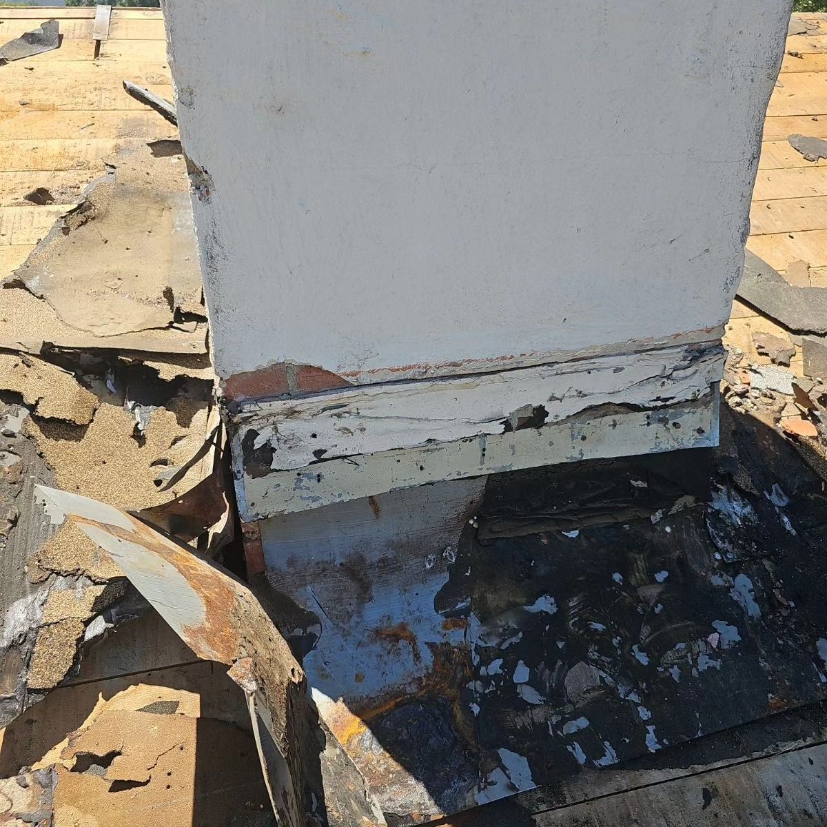 The roof of a house has a chimney on it