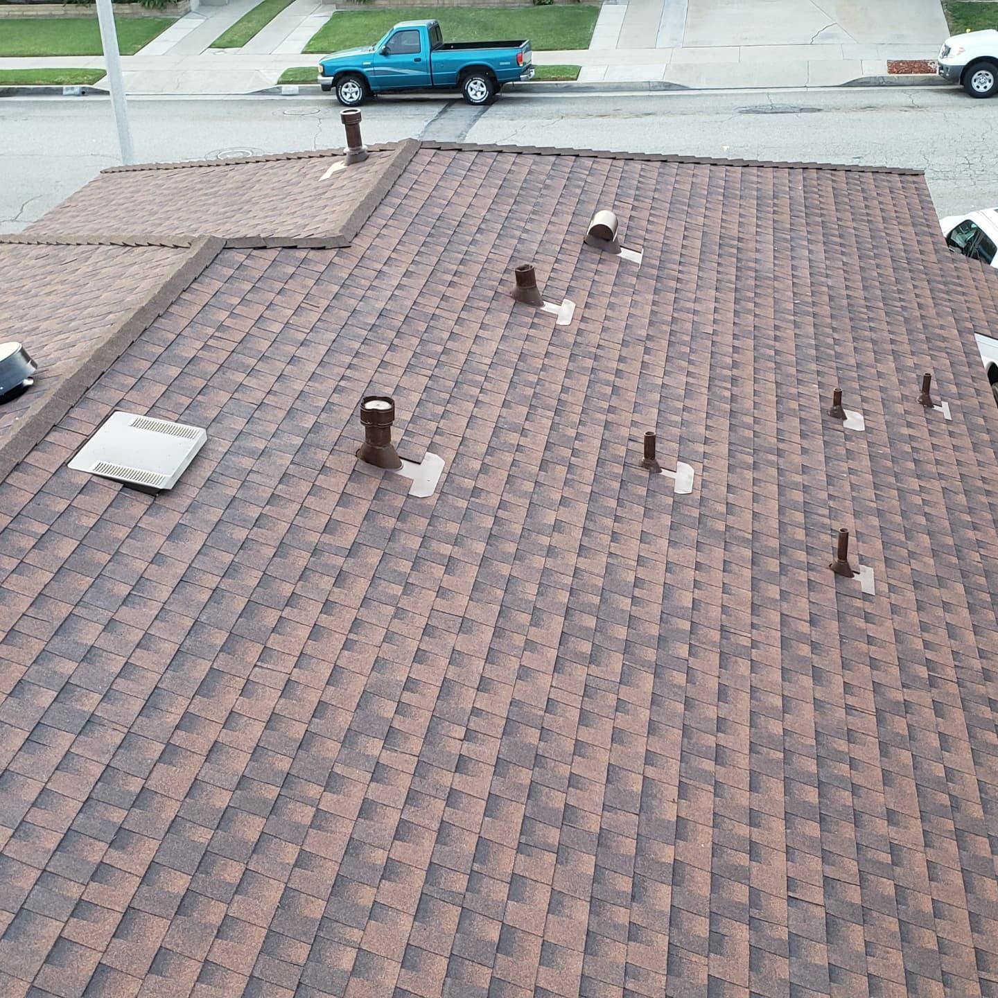 A blue truck is parked on the roof of a house