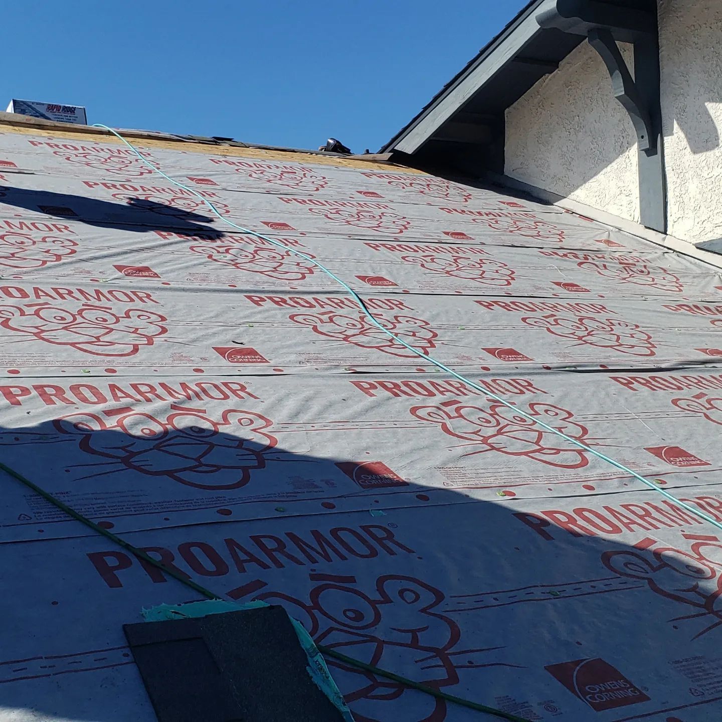 The roof of a house is being covered with proarmor