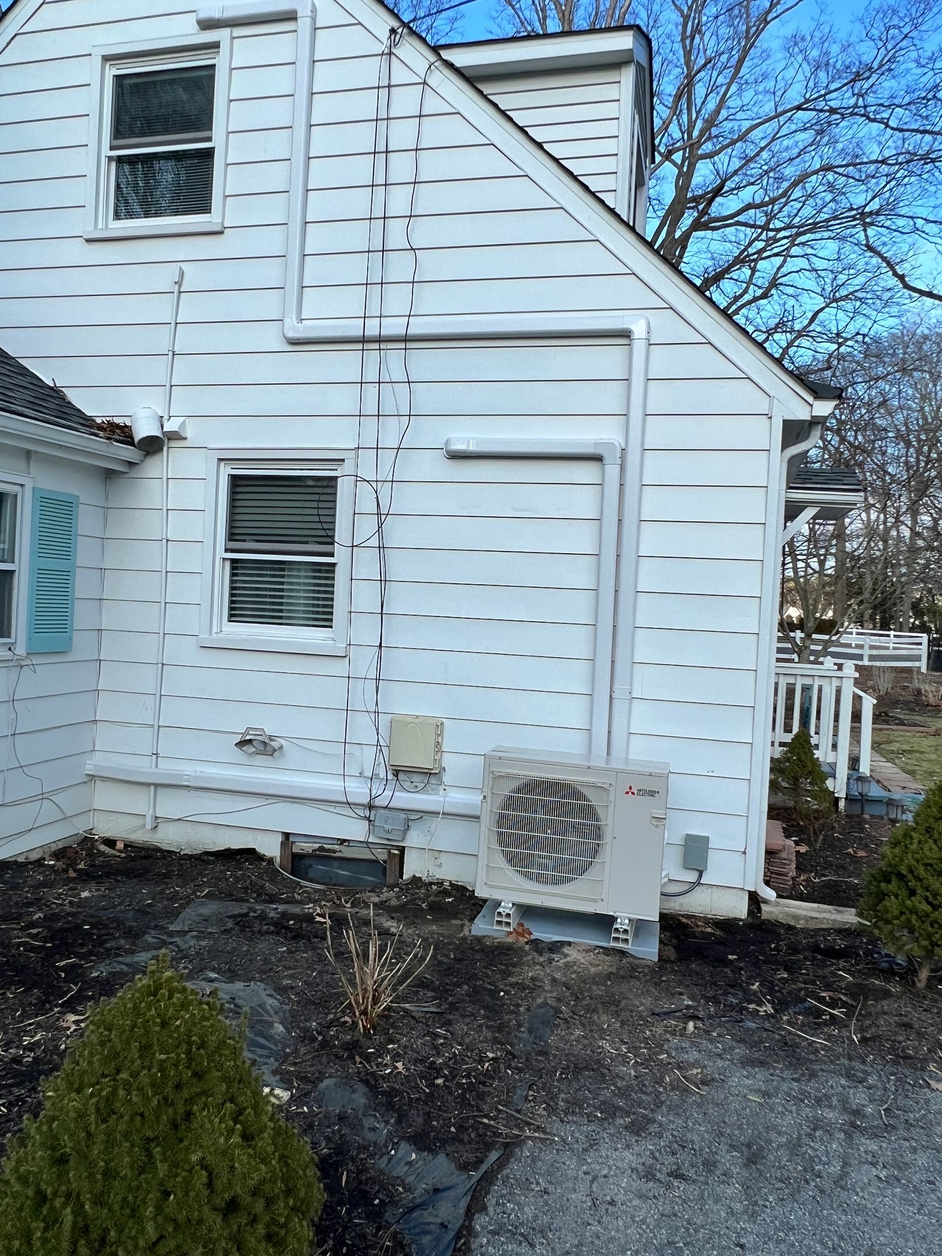 A white house with a large air conditioner on the side of it.