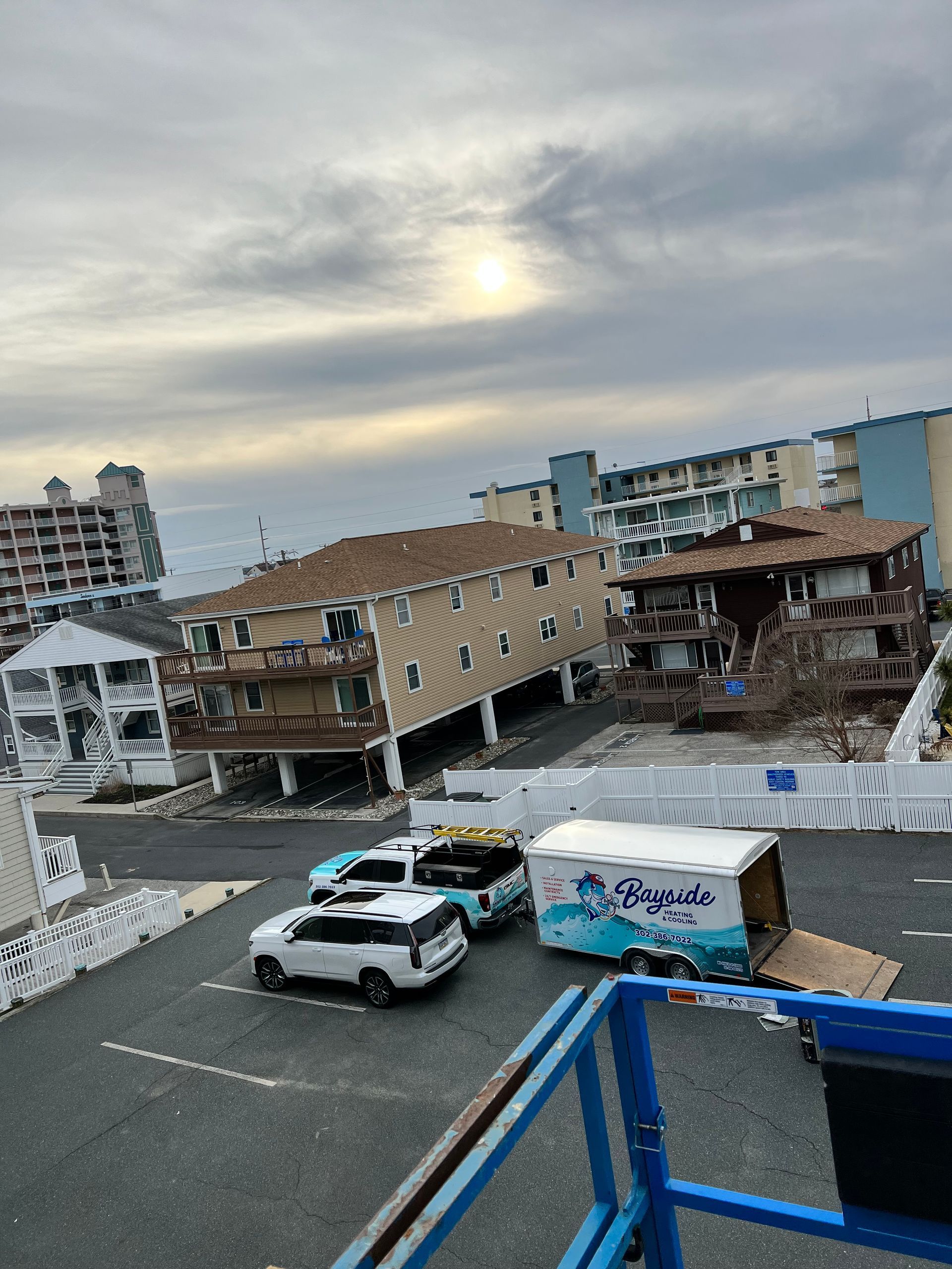 A bunch of cars are parked in a parking lot in front of a building.