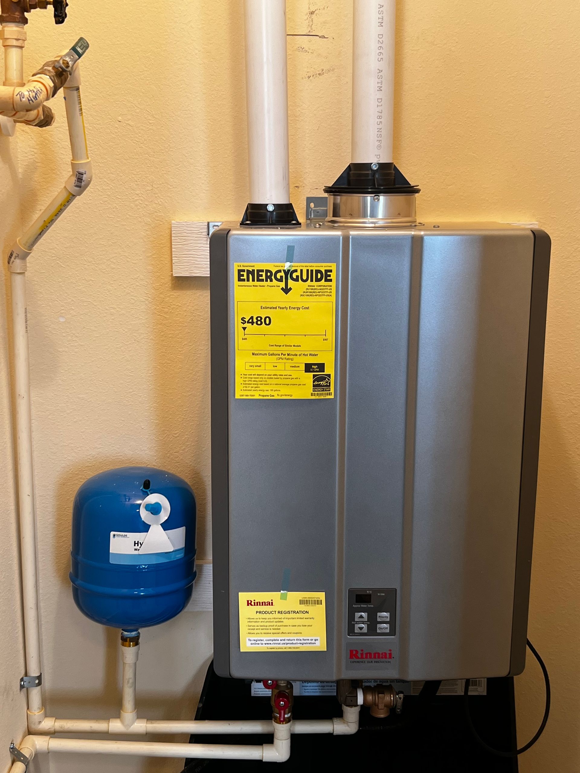 A water heater with a yellow sticker on it
