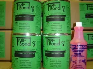 Green True-Bond cement cans stacked beside a pink bottle on a shelf.