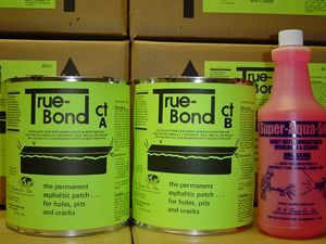 Two green True-Bond adhesive cans and a pink bottle on a shelf display