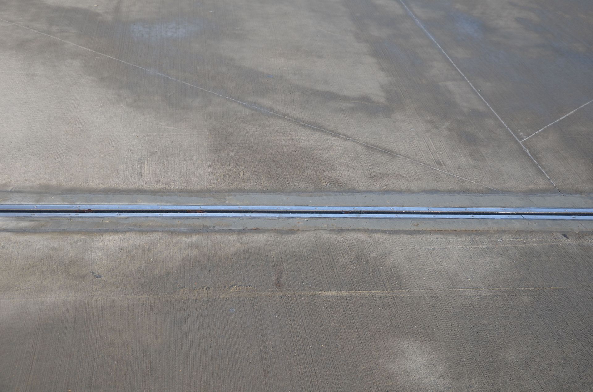 Close-up of a gray concrete surface with a thin blue painted line across it