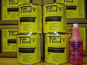 Yellow True-Bond glue cans and boxes stacked behind a pink bottle on a shelf.