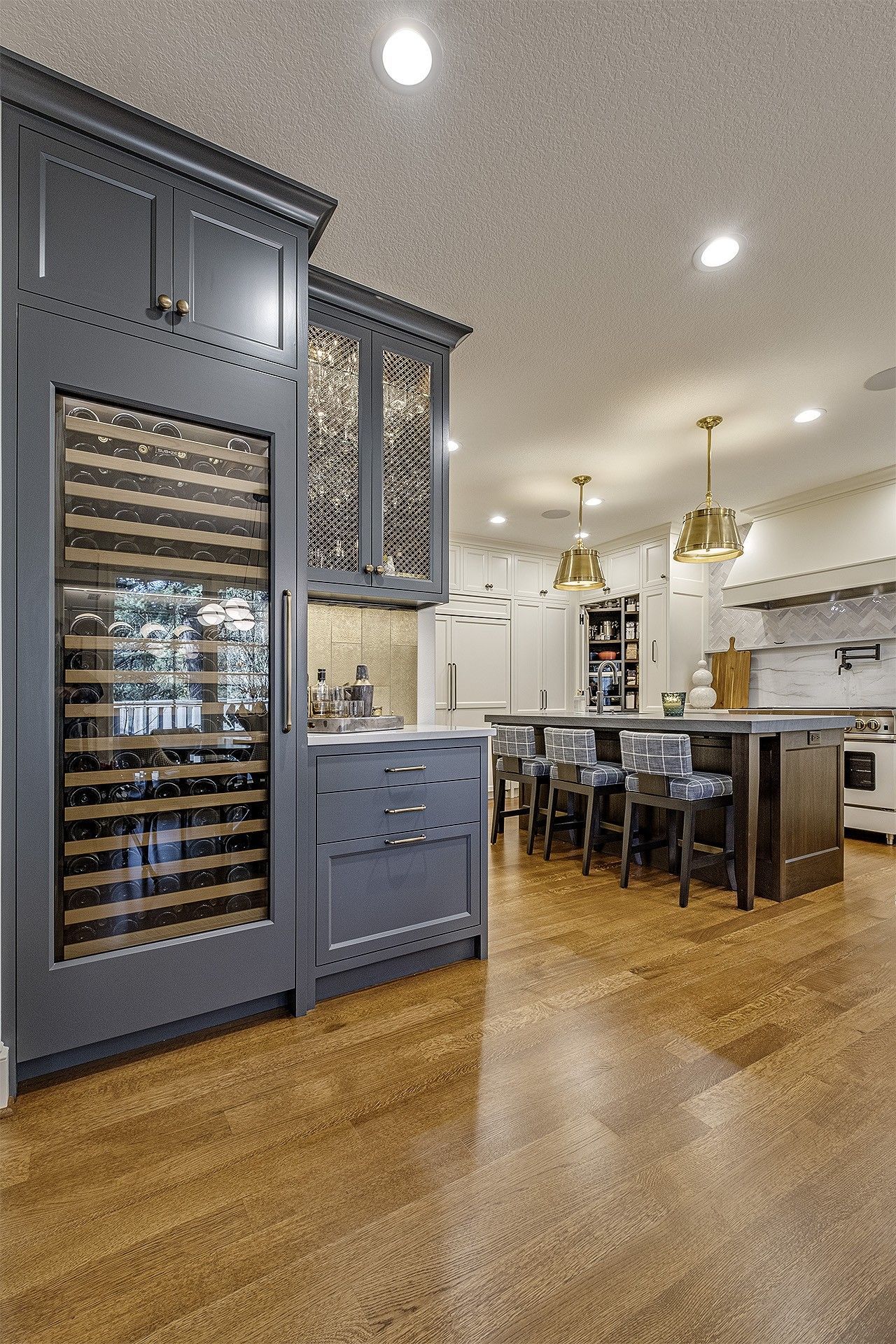 A kitchen with a large wine cooler in the middle of the room.