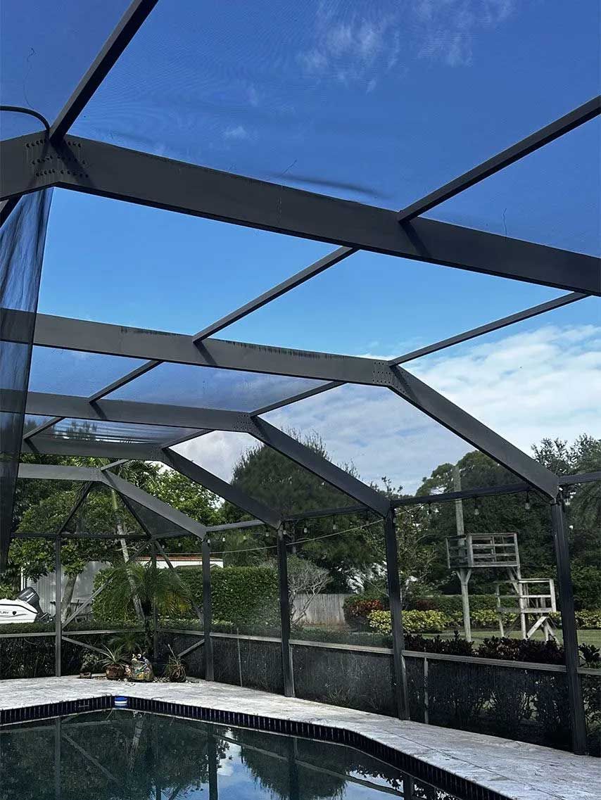 Pool enclosure with a blue sky above the pool.
