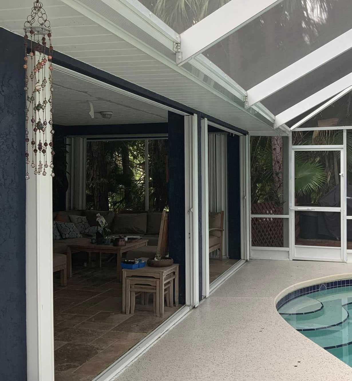 Patio doors open to a screened pool area. Blue walls and ceiling with a neutral floor.