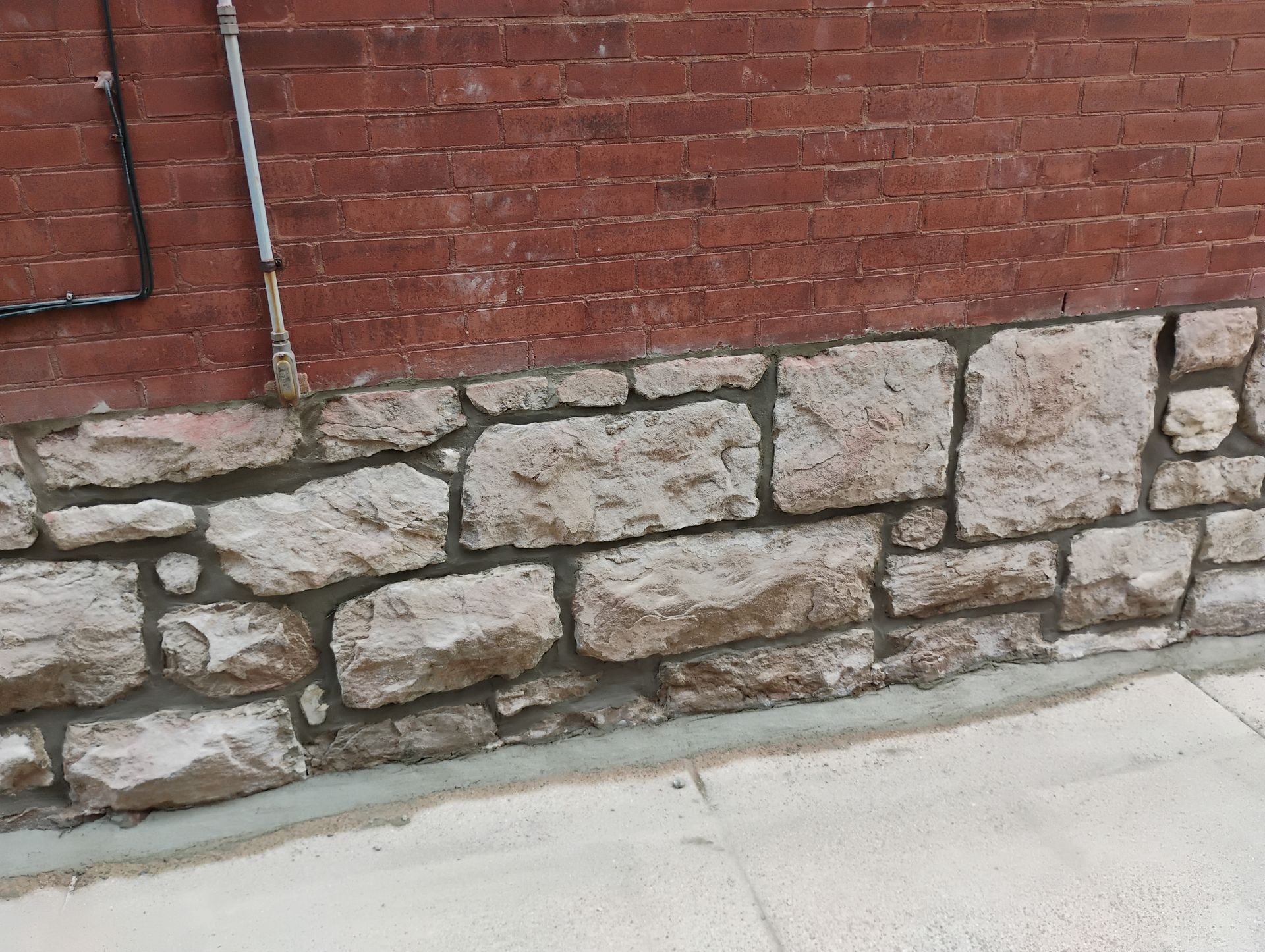 A stone wall with a brick wall behind it