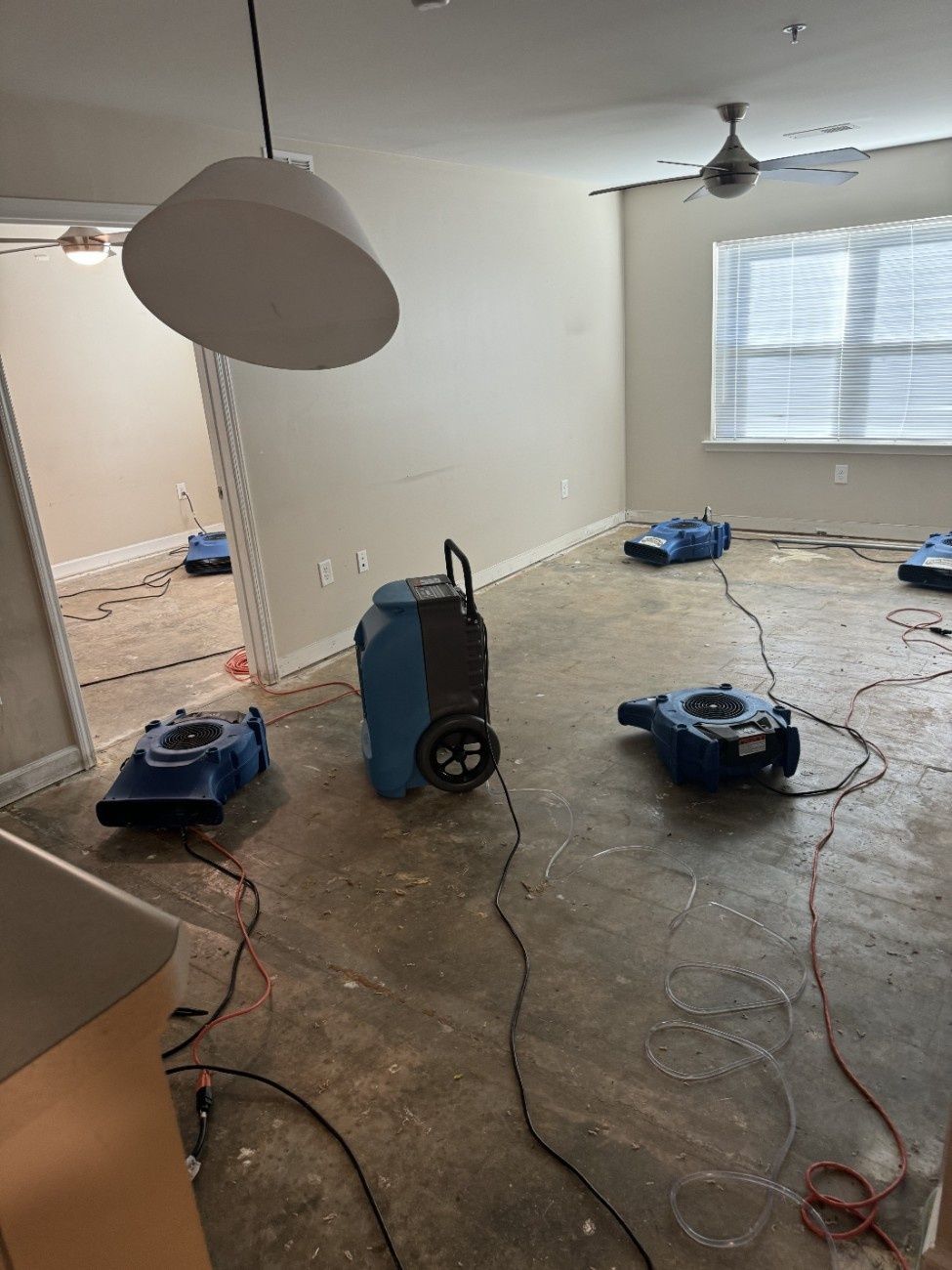 Dehumidifiers in a flooded room, drying the floors and walls.