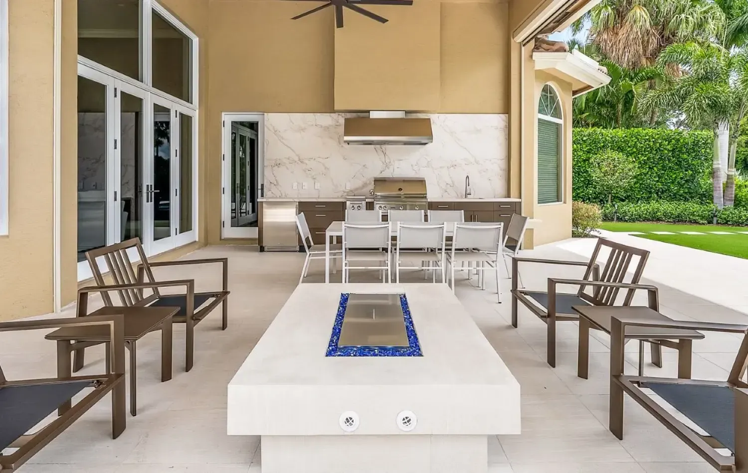 Outdoor patio with a fire pit, seating area, and outdoor kitchen.