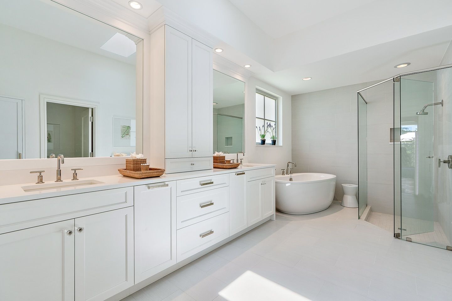 Bright white bathroom with a vanity, shower, and freestanding tub.