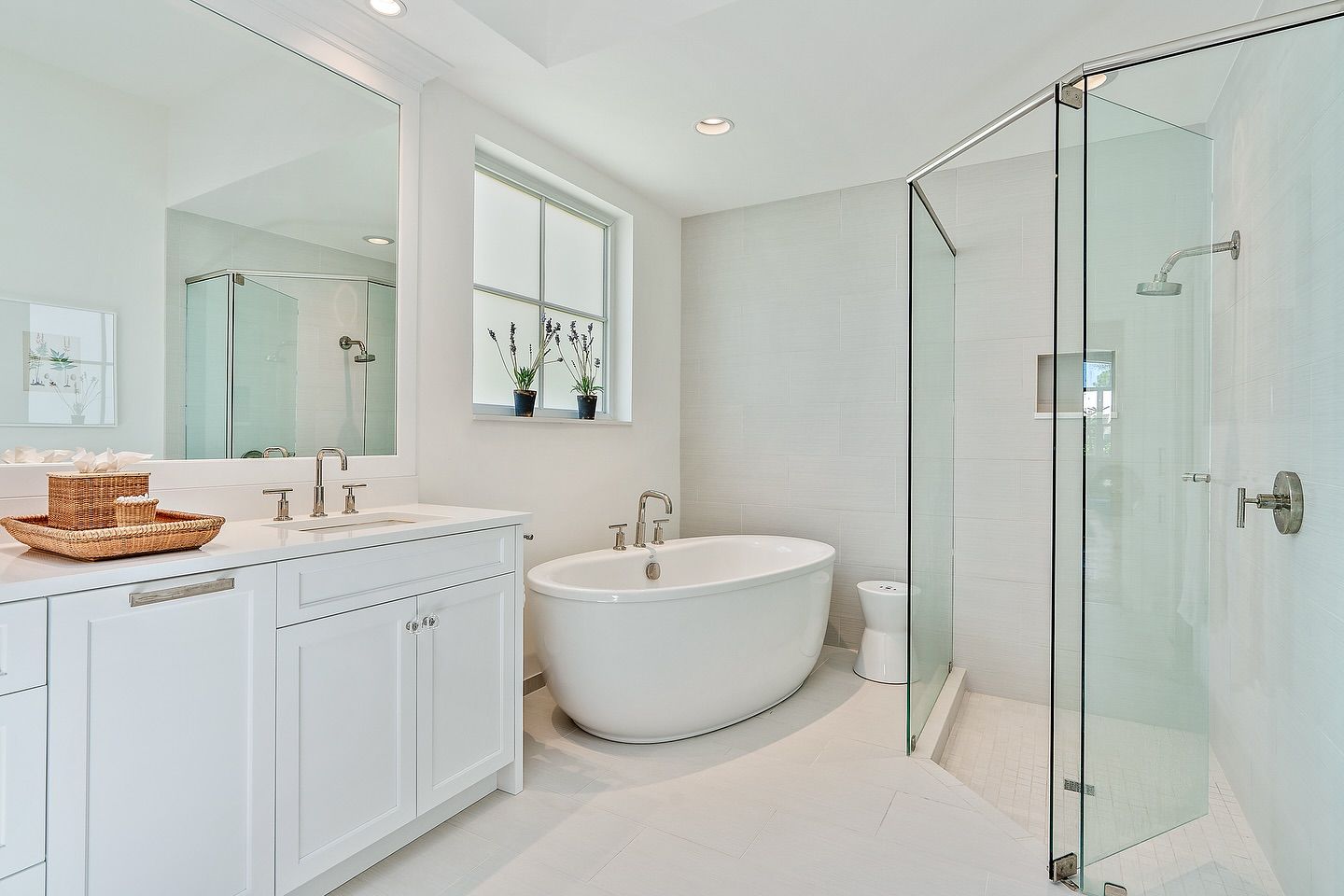 Bright white bathroom with a freestanding tub, glass shower, and vanity.