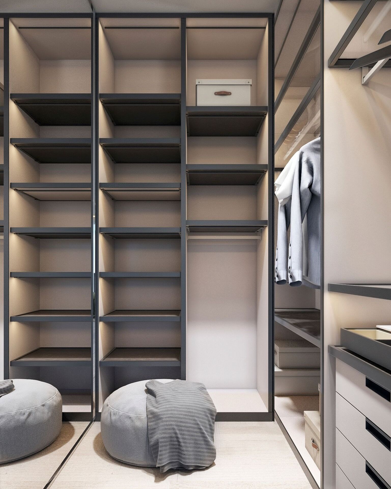 Walk-in closet with shelves, hanging rod, and drawers; gray, black, and beige color scheme; two poufs on the floor.