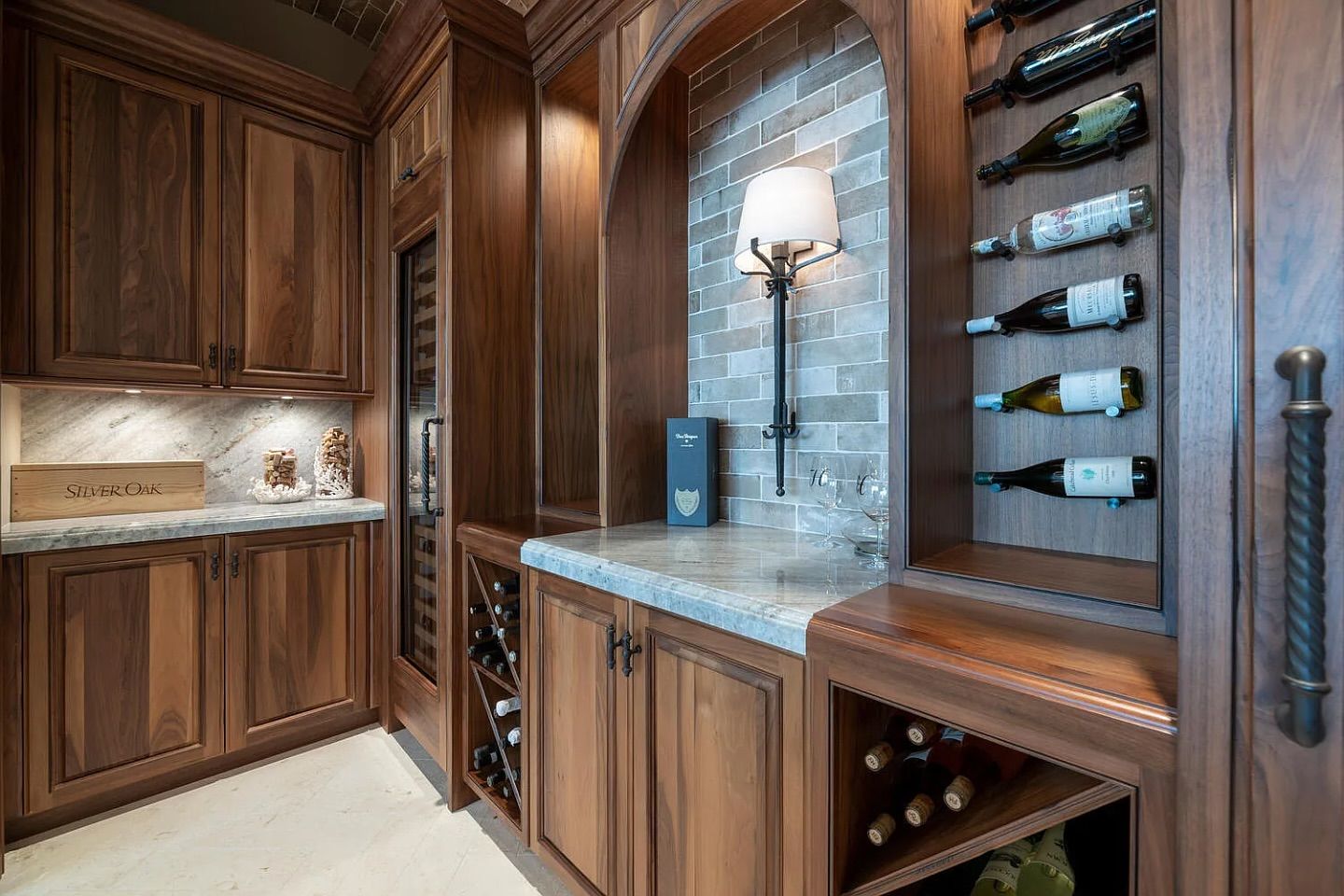 Wine cellar with wooden cabinets, stone countertop, and built-in wine storage.