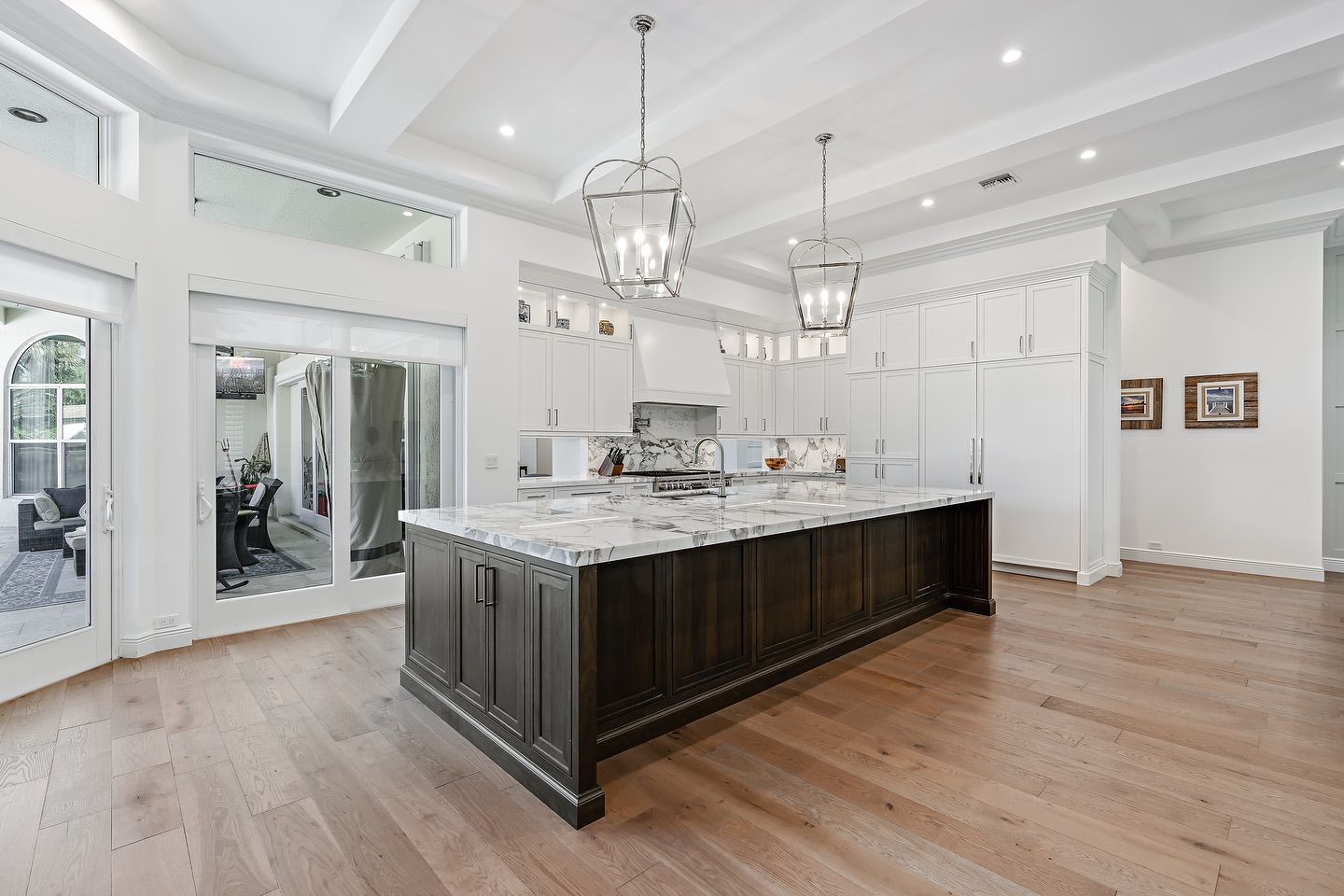 Spacious kitchen with a large dark wood island, white countertops, and wood floors.