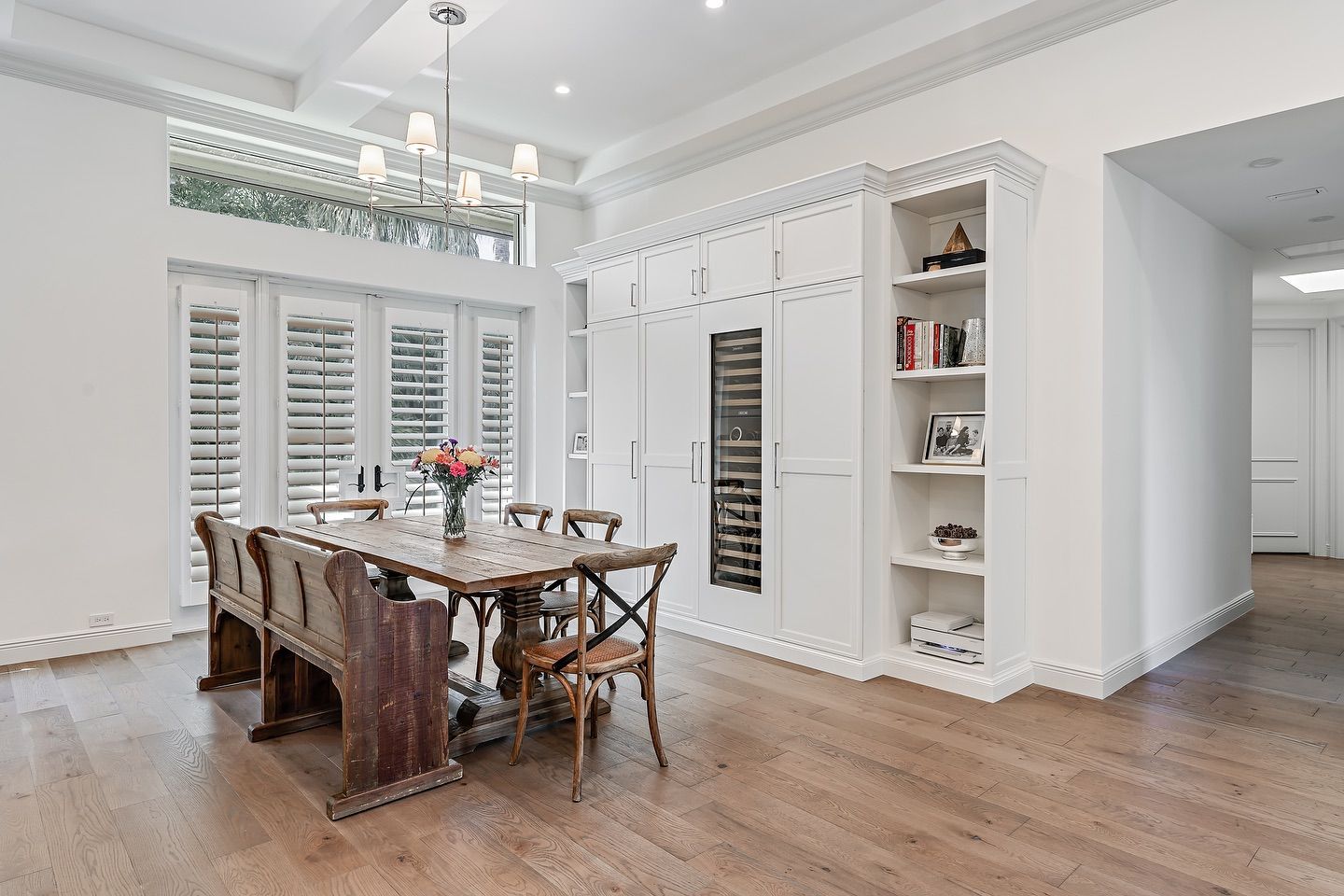 Dining room with a wooden table, chairs, and white built-in storage.